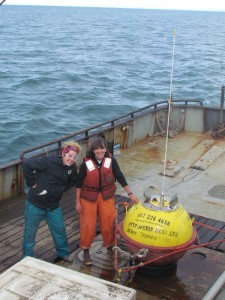 Starr Brainard and Kris Holderied of NOAA's Kasitsna Bay Lab help launch the buoy while on a mission to collect oceanographic samples as part of the GulfWatch Alaska program.