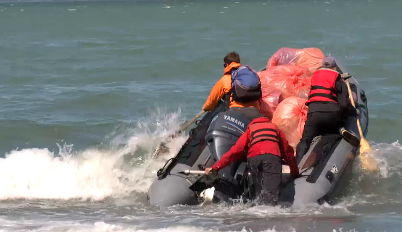 A team of scientist, artists, and filmmakers haul garbage off a beach near Kodiak.